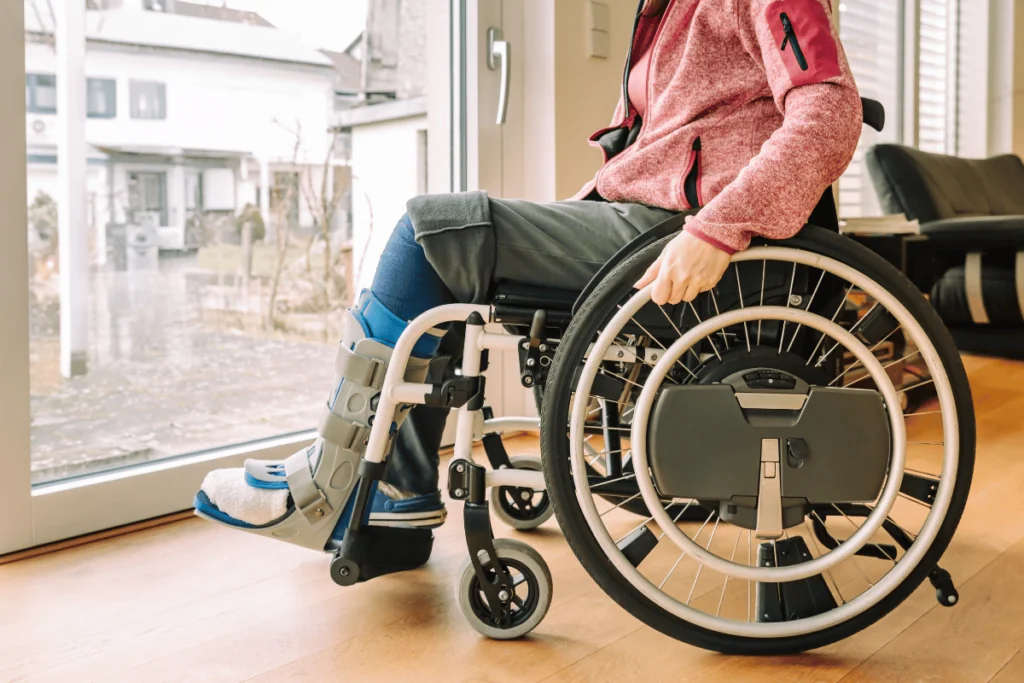 A woman using a wheelchair with her leg in a brace