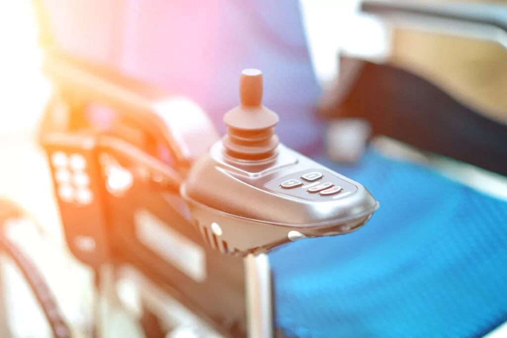 A controller on a blue power wheelchair in El Paso.