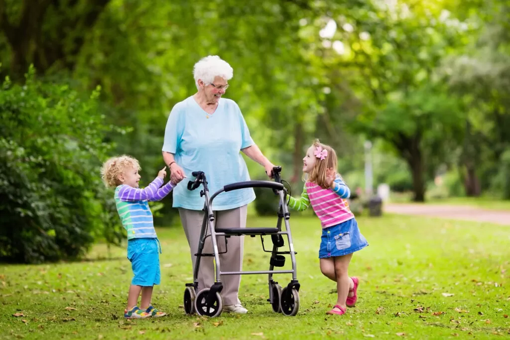 A woman with a walker and two small smiling children in El Paso.